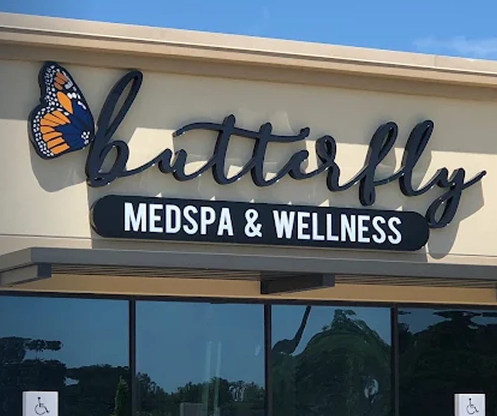 Butterfly Medspa & Wellness storefront sign with orange and black butterfly logo and blue lettering on building exterior