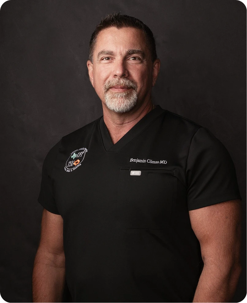 Benjamin Cilieno MD in black scrubs with clinic logo, against dark background