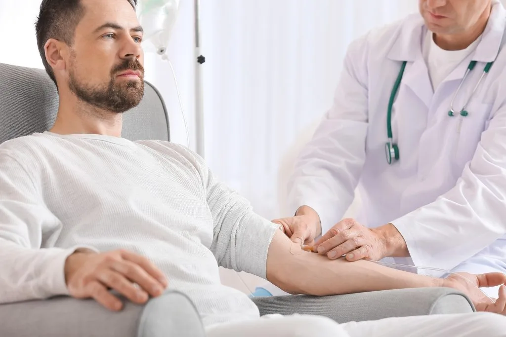 Doctor examining male patient's arm during medical consultation in clinic