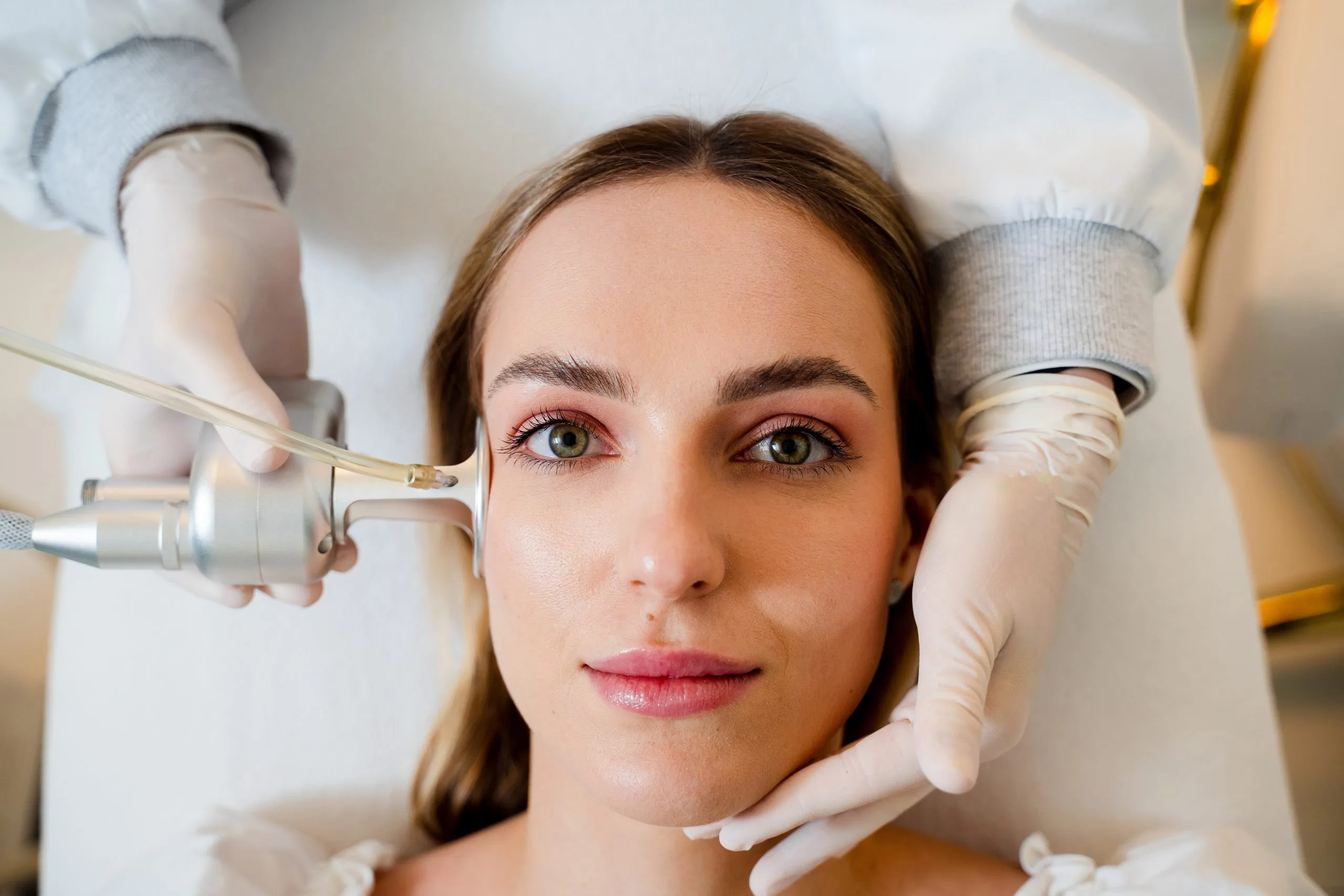 Provider using radiofrequency device on patient's face during skin treatment